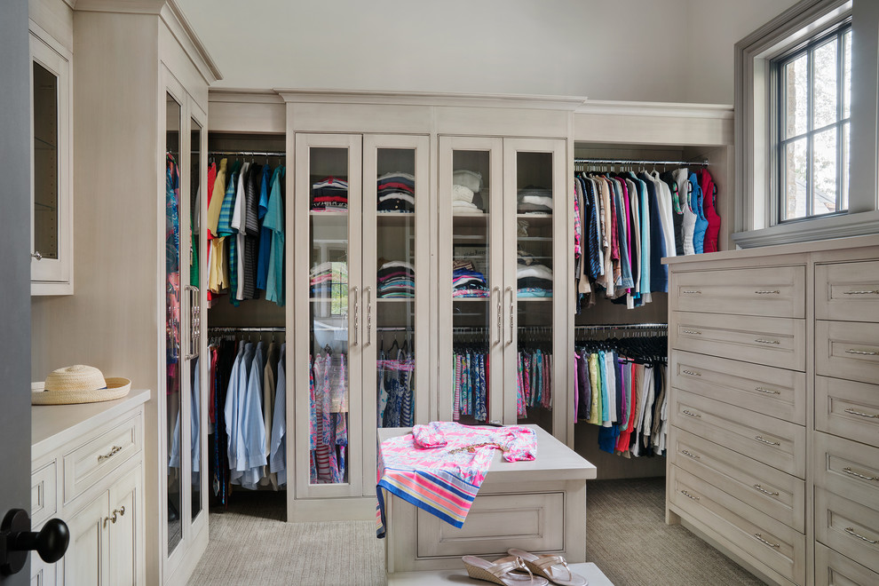 Imagen de armario vestidor clásico con puertas de armario beige, moqueta y suelo beige
