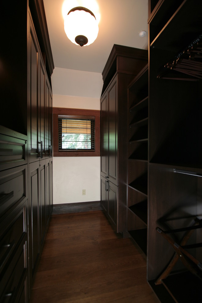 На фото: гардеробная комната среднего размера, унисекс в классическом стиле с фасадами с выступающей филенкой, темными деревянными фасадами и темным паркетным полом с