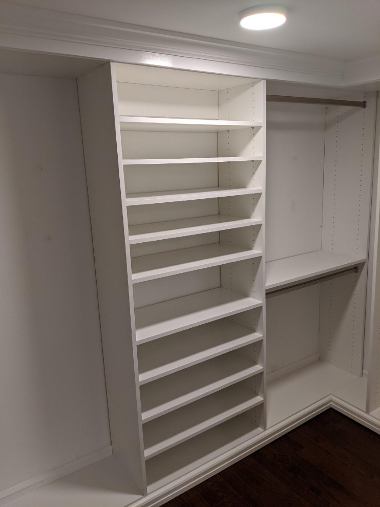Ejemplo de armario y vestidor unisex clásico de tamaño medio con a medida, puertas de armario blancas, suelo de madera oscura y suelo marrón