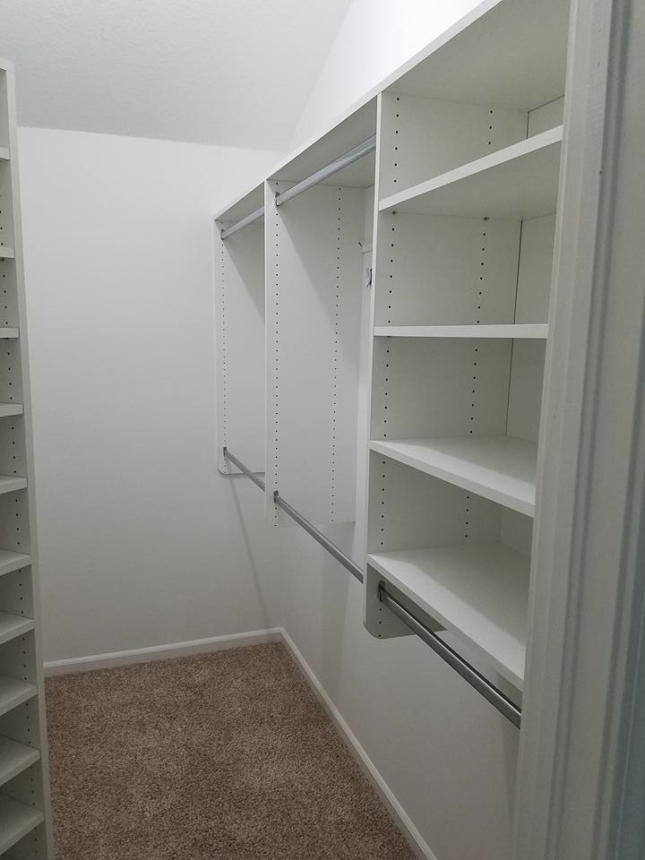 Inredning av ett klassiskt mellanstort walk-in-closet för könsneutrala, med öppna hyllor, vita skåp, heltäckningsmatta och beiget golv
