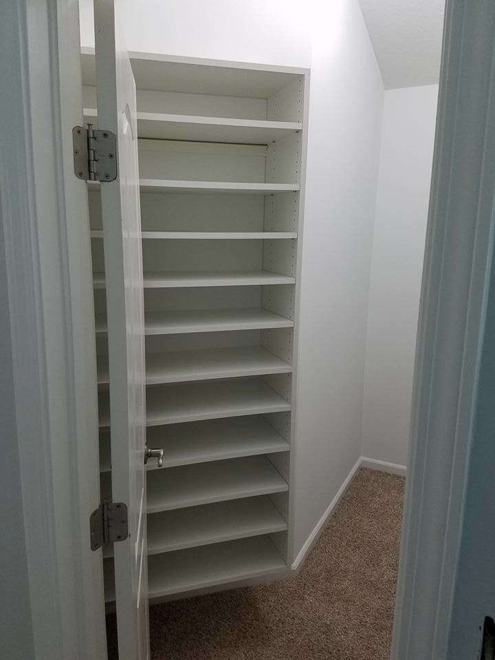 Mid-sized elegant gender-neutral carpeted and beige floor walk-in closet photo in Jacksonville with open cabinets and white cabinets