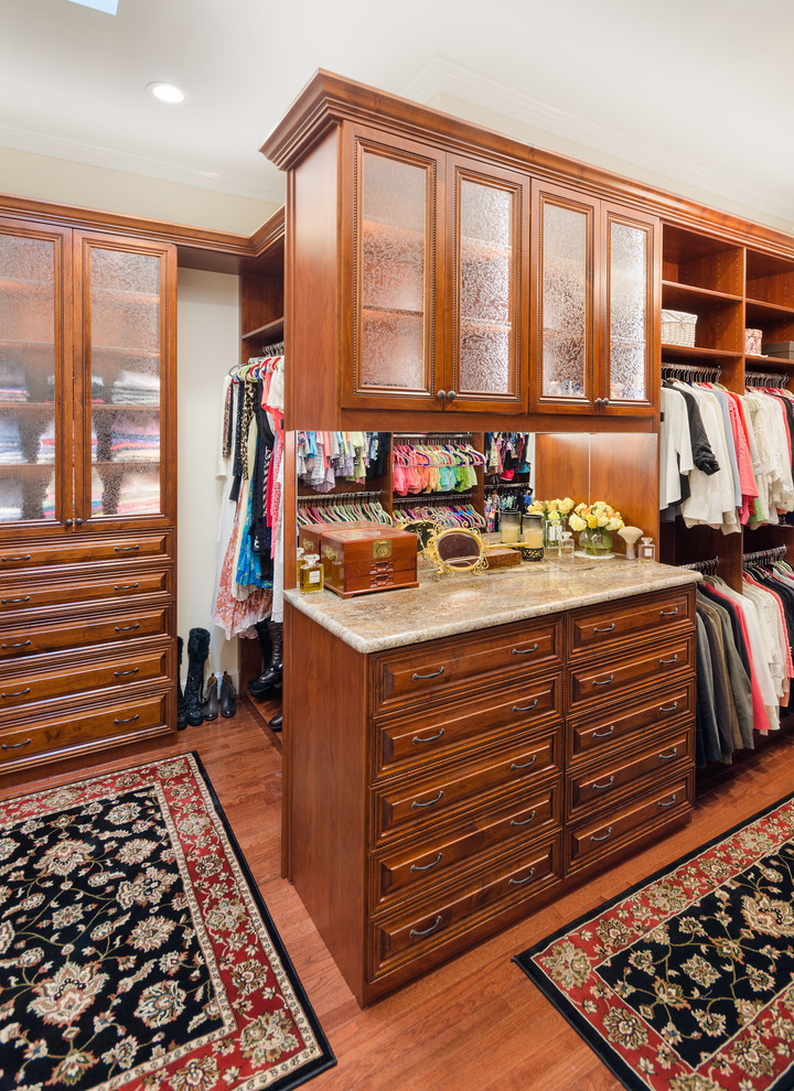 Modelo de armario y vestidor unisex tradicional con armarios con paneles con relieve, puertas de armario de madera oscura y suelo marrón