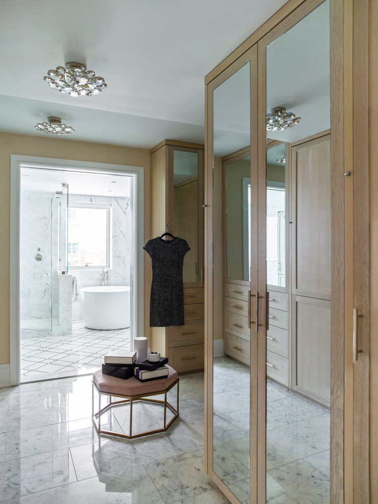 This is an example of a classic wardrobe in New York with shaker cabinets, medium wood cabinets and grey floors.
