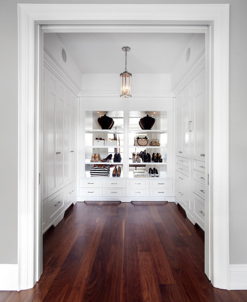 Foto de armario y vestidor tradicional renovado con puertas de armario blancas y suelo de madera oscura