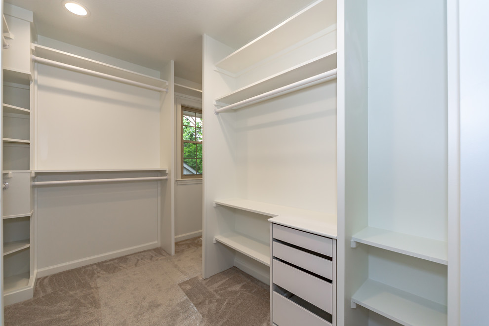 Large traditional gender neutral walk-in wardrobe in Kansas City with open cabinets, white cabinets, carpet and beige floors.