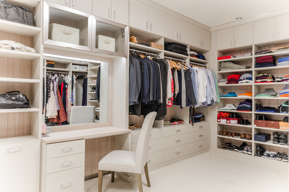 Minimalist gender-neutral carpeted and beige floor walk-in closet photo in New York with open cabinets and beige cabinets