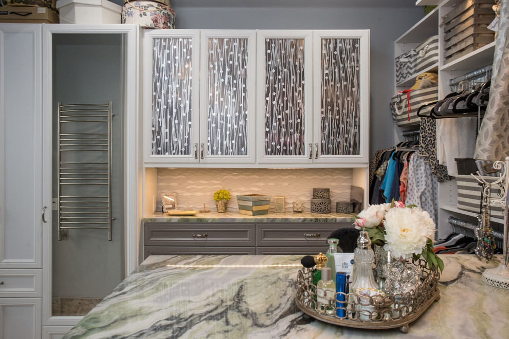 Medium sized traditional gender neutral walk-in wardrobe in Austin with recessed-panel cabinets, white cabinets, travertine flooring and grey floors.