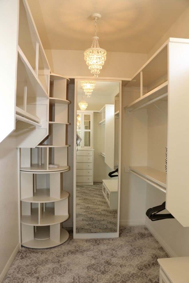 На фото: гардеробная комната в стиле неоклассика (современная классика) с фасадами с выступающей филенкой, белыми фасадами, ковровым покрытием и серым полом для женщин