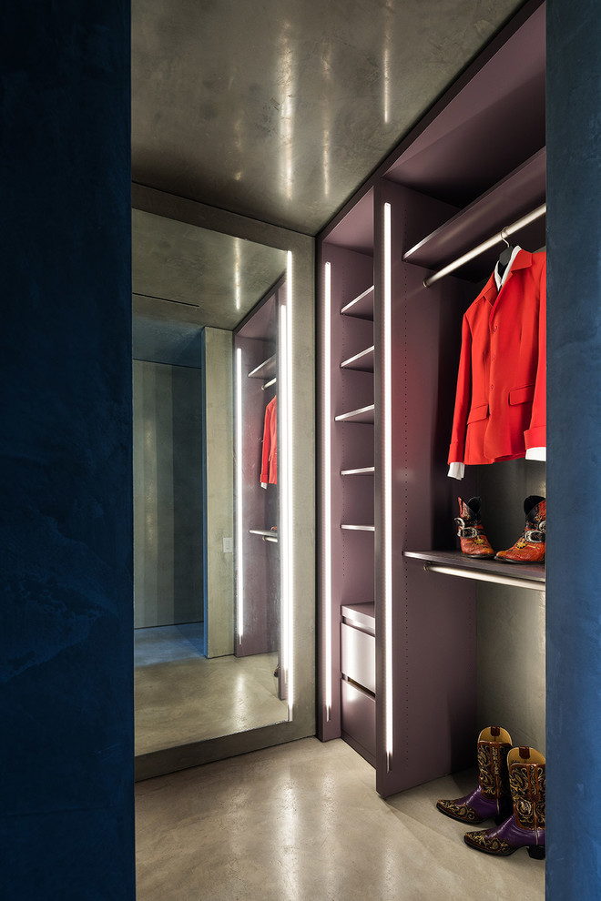 Diseño de armario vestidor unisex moderno de tamaño medio con suelo de cemento