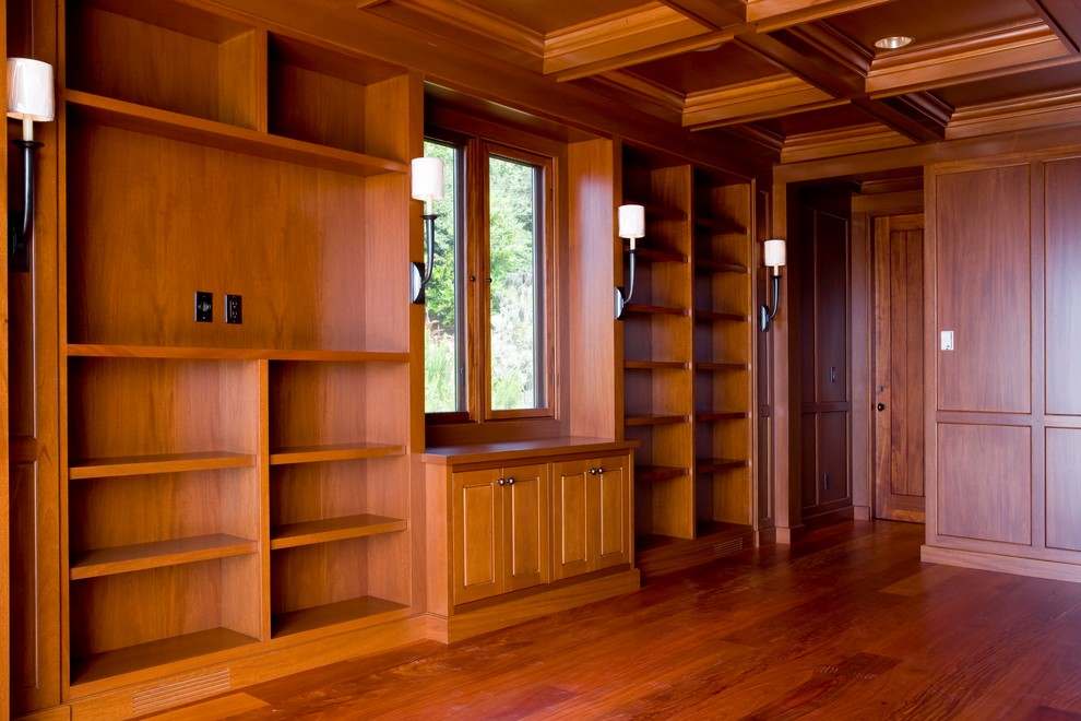 Exemple d'un très grand dressing room exotique en bois foncé avec un placard avec porte à panneau surélevé, parquet foncé et un sol marron.
