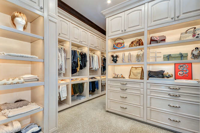 Walk-in closet - huge mediterranean gender-neutral carpeted and beige floor walk-in closet idea in Tampa with raised-panel cabinets and distressed cabinets