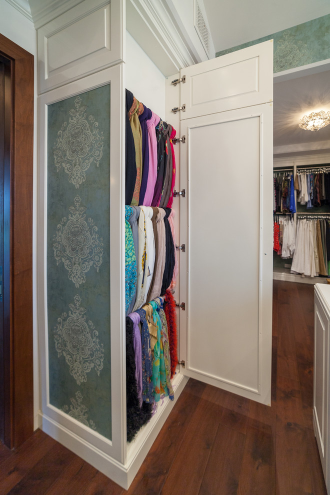 Diseño de vestidor de mujer mediterráneo grande con armarios con paneles con relieve, puertas de armario blancas, suelo de madera en tonos medios y suelo marrón