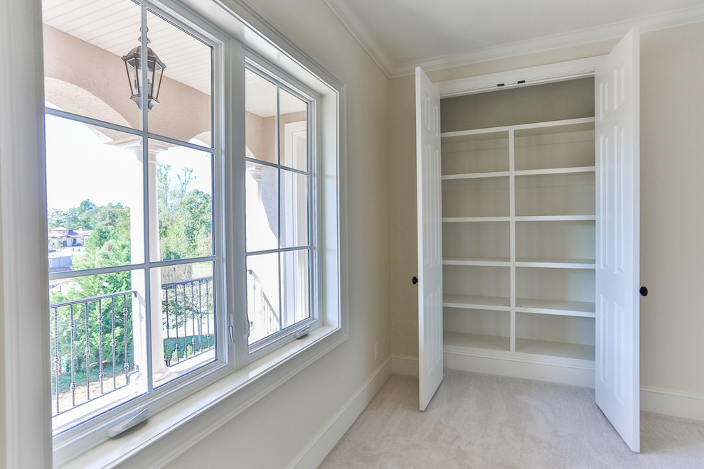 Example of a small tuscan gender-neutral carpeted and beige floor reach-in closet design in Raleigh with open cabinets and white cabinets