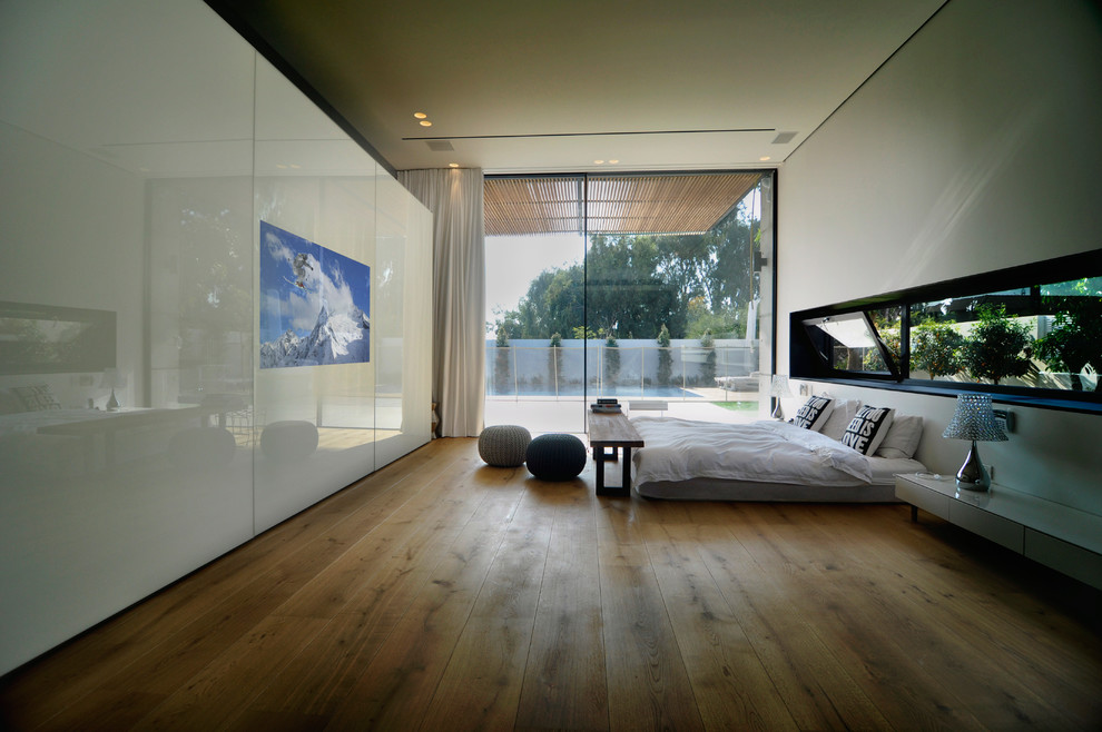 Esempio di un grande spazio per vestirsi unisex design con ante di vetro, ante bianche e pavimento in legno massello medio