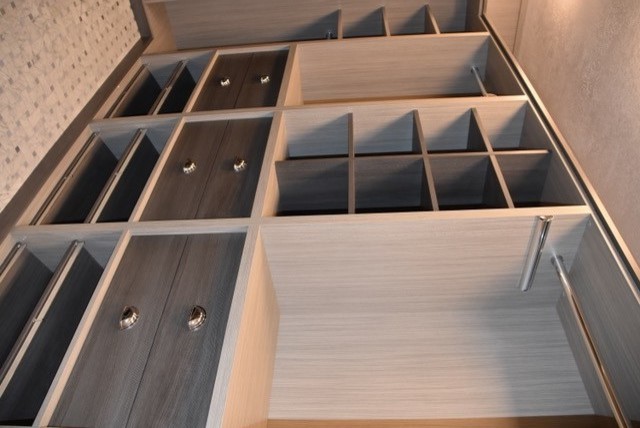 Design ideas for a small contemporary gender neutral walk-in wardrobe with glass-front cabinets and grey cabinets.