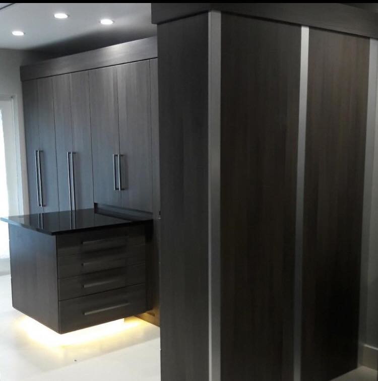 Large trendy men's marble floor and beige floor walk-in closet photo in Miami with flat-panel cabinets and gray cabinets
