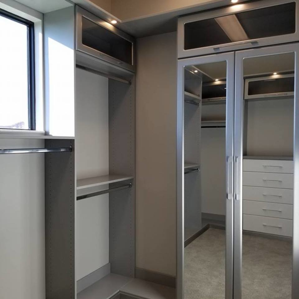 Idee per una grande cabina armadio unisex minimal con ante di vetro, ante grigie, moquette e pavimento grigio