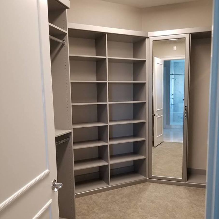 Photo of a large contemporary gender neutral walk-in wardrobe in Miami with glass-front cabinets, grey cabinets, carpet and grey floors.