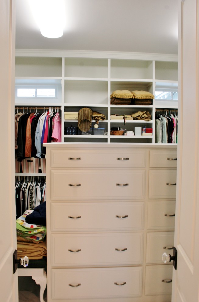 Inspiration for a gender neutral dressing room in Miami with raised-panel cabinets and white cabinets.