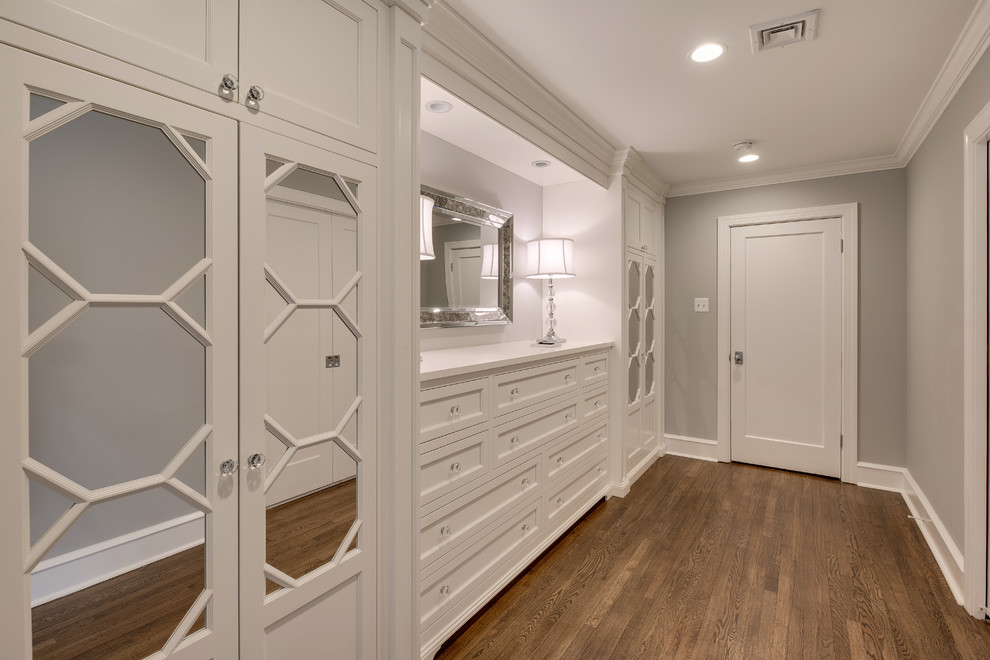 Medium sized traditional gender neutral walk-in wardrobe in Philadelphia with medium hardwood flooring, recessed-panel cabinets, white cabinets and brown floors.