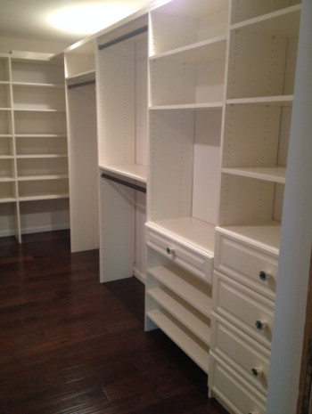Example of a mid-sized eclectic gender-neutral dark wood floor walk-in closet design in Columbus with recessed-panel cabinets and beige cabinets