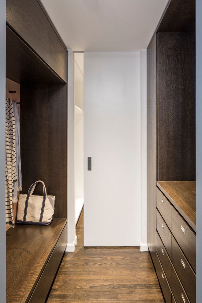Mittelgroßer, Neutraler Moderner Begehbarer Kleiderschrank mit flächenbündigen Schrankfronten, hellbraunen Holzschränken und braunem Holzboden in New York