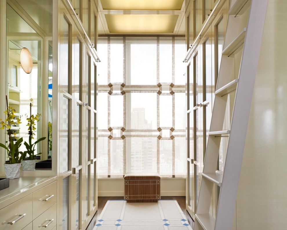 Design ideas for a classic gender neutral walk-in wardrobe in New York with beige cabinets.