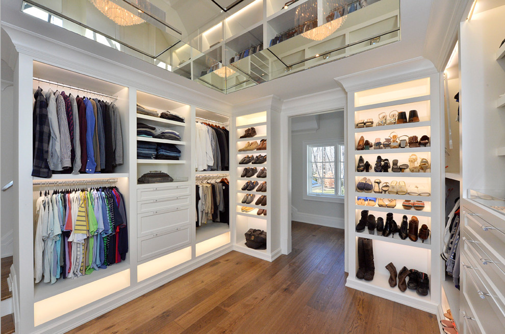 Ejemplo de armario vestidor unisex tradicional renovado grande con armarios abiertos, puertas de armario blancas, suelo de madera en tonos medios y suelo marrón