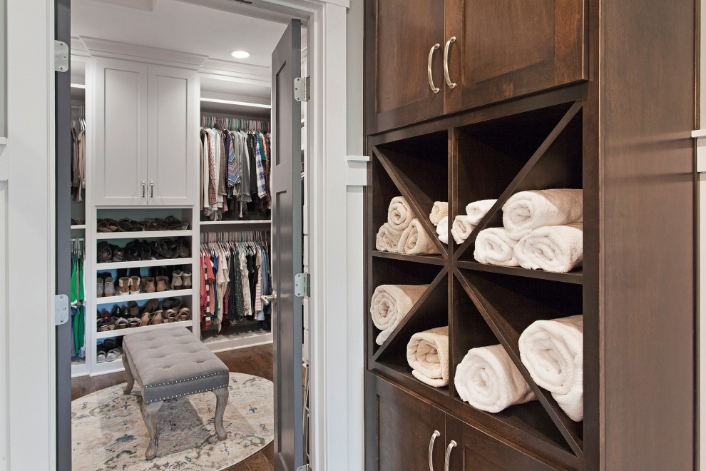 Imagen de armario vestidor unisex campestre grande con armarios estilo shaker, puertas de armario blancas, suelo de madera oscura y suelo marrón