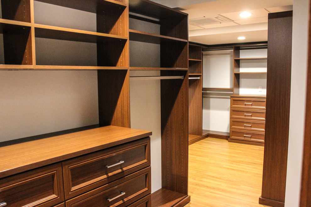 Foto de armario vestidor unisex costero grande con armarios abiertos, puertas de armario de madera oscura y suelo de madera clara