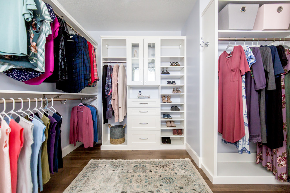 Expansive beach style walk-in wardrobe for women in Other with recessed-panel cabinets, white cabinets, medium hardwood flooring and brown floors.
