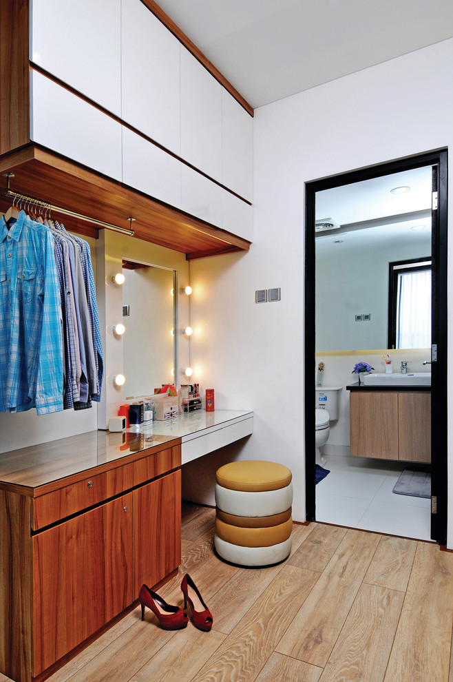 Idée de décoration pour un petit dressing room design en bois clair neutre avec un placard sans porte et parquet clair.