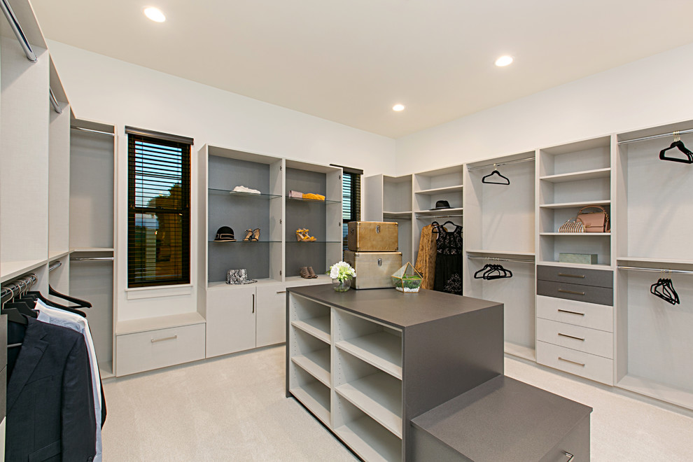 Пример оригинального дизайна: большая гардеробная комната унисекс в стиле кантри с открытыми фасадами, серыми фасадами, ковровым покрытием и белым полом