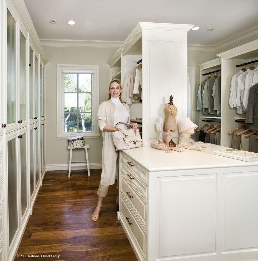Large elegant gender-neutral medium tone wood floor and brown floor walk-in closet photo in San Francisco with raised-panel cabinets and white cabinets