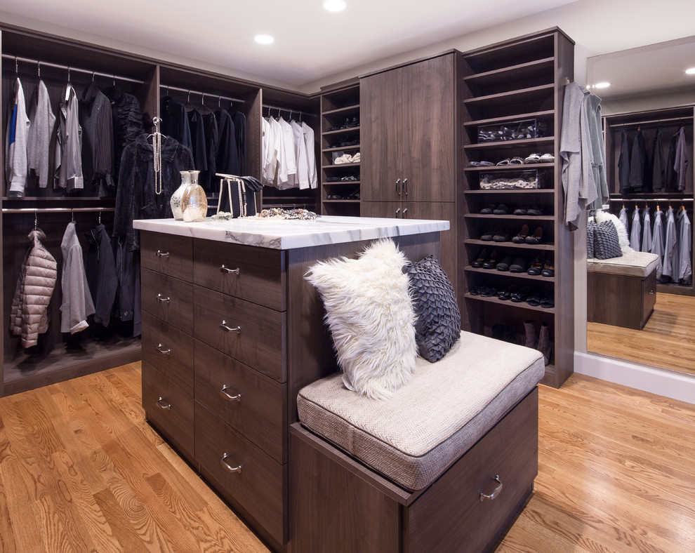Imagen de armario vestidor unisex contemporáneo grande con armarios con paneles lisos, suelo de madera en tonos medios y puertas de armario marrones
