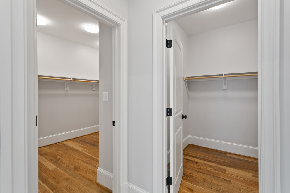 Design ideas for a medium sized contemporary gender neutral walk-in wardrobe in Other with medium hardwood flooring and brown floors.