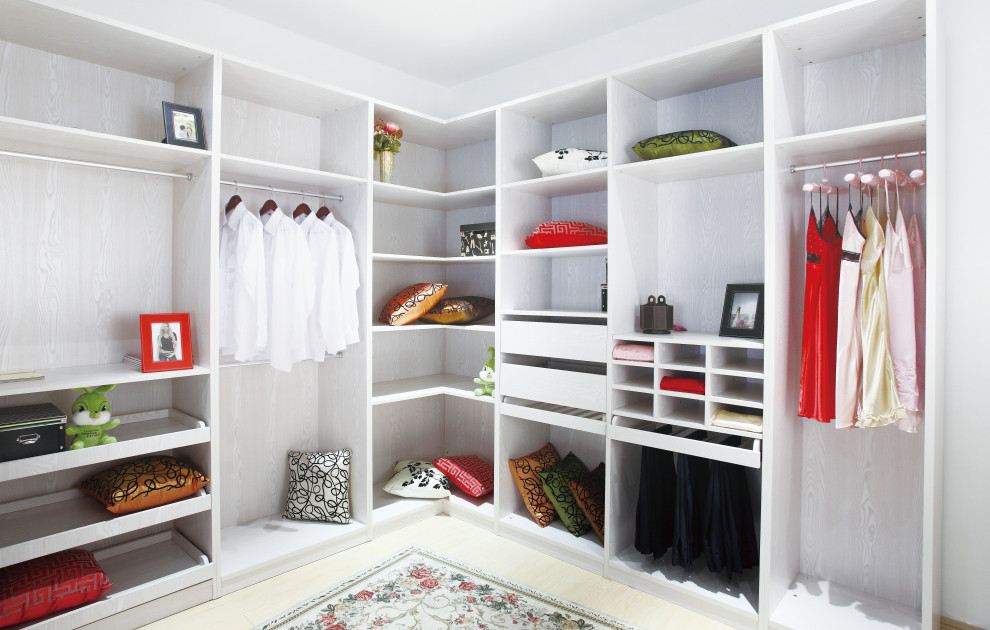 This is an example of a medium sized contemporary walk-in wardrobe for women in Los Angeles with flat-panel cabinets, light wood cabinets and laminate floors.