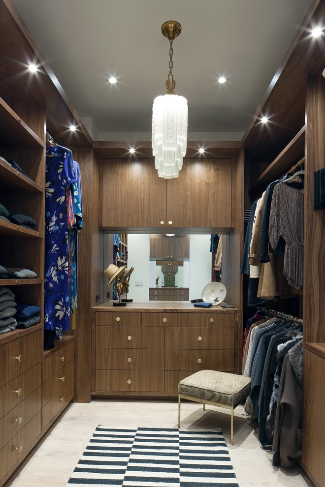 Inspiration for a large contemporary women's light wood floor and beige floor walk-in closet remodel in Los Angeles with flat-panel cabinets and medium tone wood cabinets