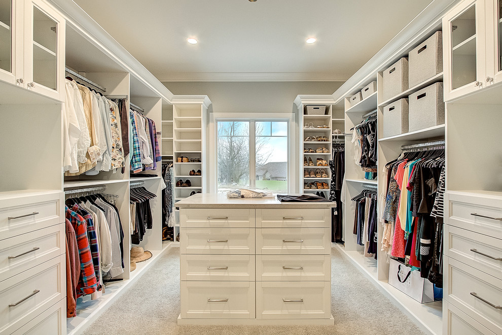 Inspiration for a traditional gender neutral dressing room in Milwaukee with recessed-panel cabinets, white cabinets, carpet and beige floors.