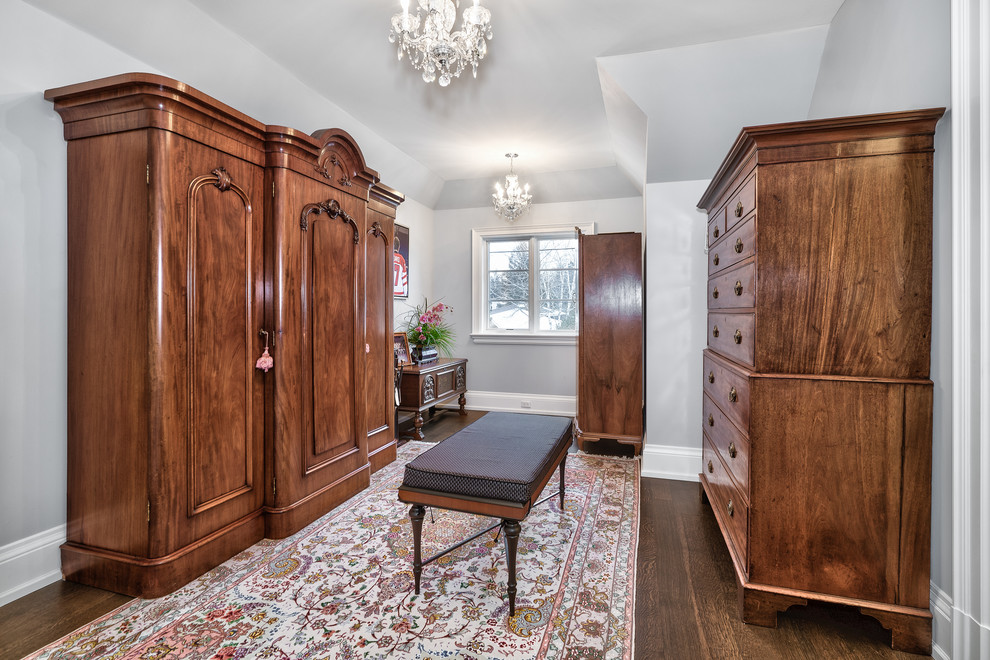 This is an example of a large traditional gender neutral dressing room in Toronto with dark hardwood flooring and brown floors.