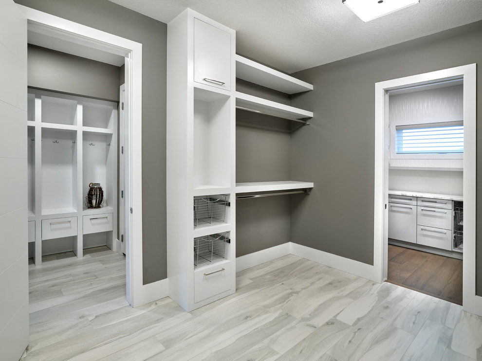 Ejemplo de armario vestidor unisex actual grande con armarios abiertos, puertas de armario blancas, suelo de baldosas de porcelana y suelo gris