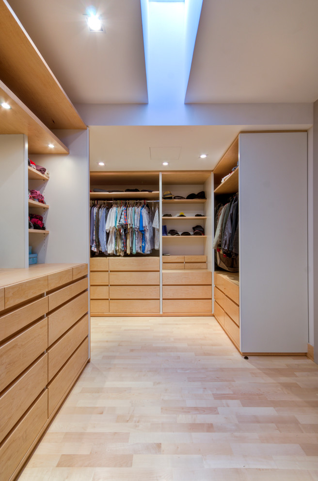 Example of a trendy light wood floor walk-in closet design in Other with open cabinets and light wood cabinets