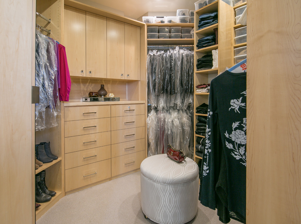This is an example of a large traditional walk-in wardrobe for women in San Francisco with flat-panel cabinets, light wood cabinets, carpet and beige floors.