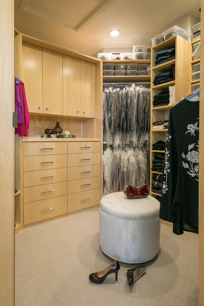 Diseño de armario vestidor de mujer clásico renovado grande con armarios con paneles lisos, puertas de armario de madera clara, moqueta y suelo beige