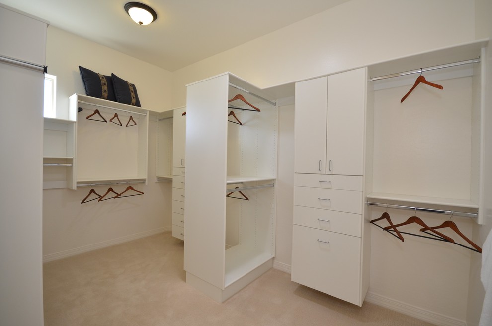 Imagen de armario vestidor unisex tradicional con armarios con paneles lisos, puertas de armario blancas y moqueta
