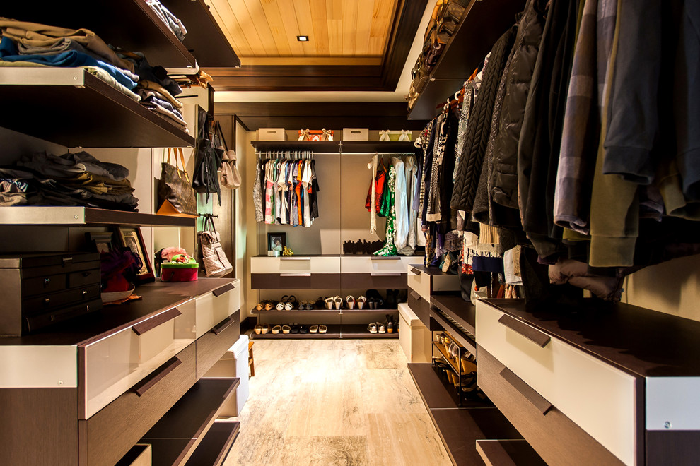 Inspiration for a medium sized world-inspired gender neutral walk-in wardrobe in Hawaii with flat-panel cabinets, dark wood cabinets, beige floors and porcelain flooring.