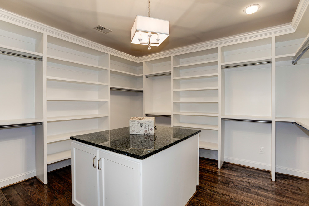 Large traditional gender neutral walk-in wardrobe in DC Metro with recessed-panel cabinets, white cabinets and dark hardwood flooring.