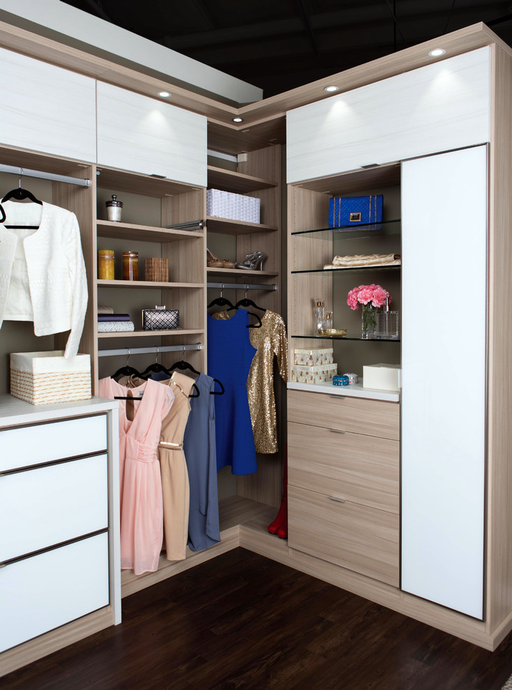 Immagine di una grande cabina armadio per donna design con ante lisce, ante bianche e parquet scuro