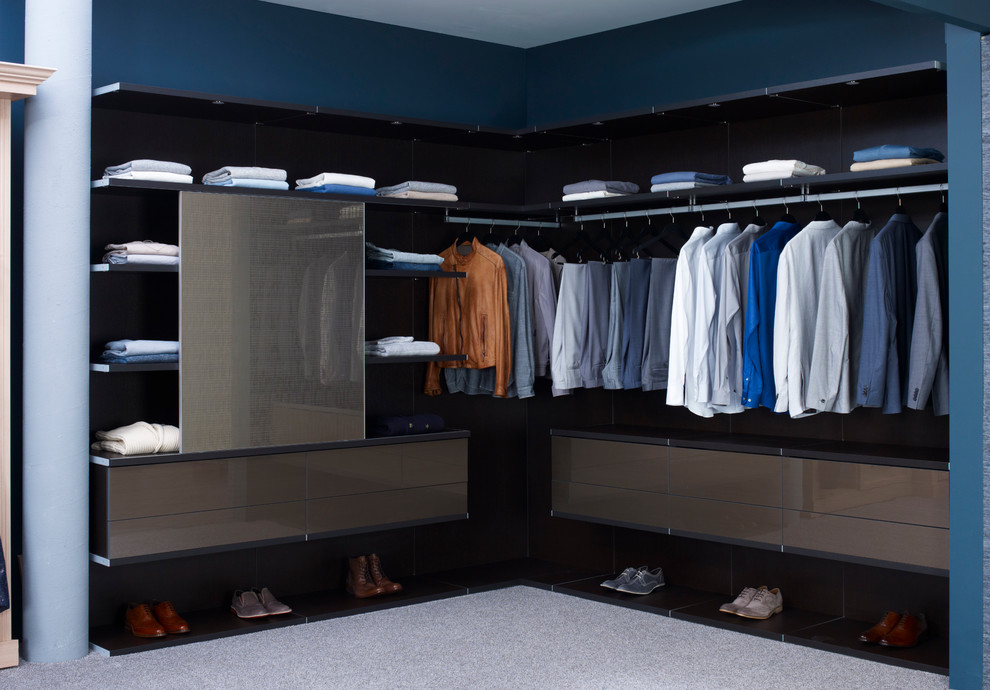 Modern inredning av ett stort walk-in-closet för män, med öppna hyllor, heltäckningsmatta och bruna skåp