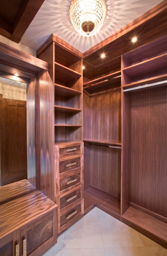 Idéer för mellanstora vintage walk-in-closets för könsneutrala, med luckor med infälld panel, skåp i mellenmörkt trä och travertin golv